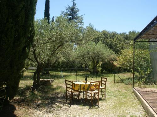 a table with a yellow table cloth on it in a yard at Pretty house 30 minutes from the beach in Vergèze