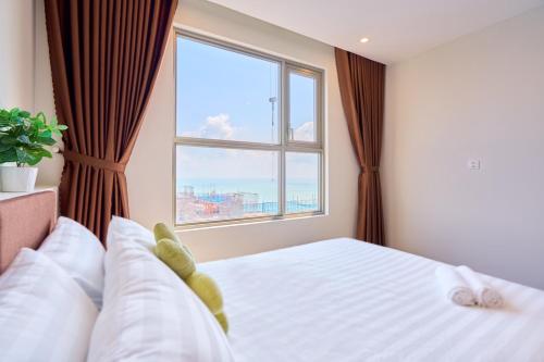 a bedroom with a bed with a large window at THE SONG- CĂN HỘ DU LỊCH 5SAO- FREE hồ bơi- Gần biển - LUXYRY PALM HOME in Vung Tau