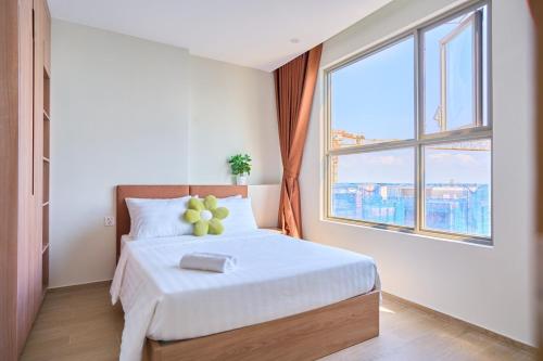 a bedroom with a bed and a large window at THE SONG- CĂN HỘ DU LỊCH 5SAO- FREE hồ bơi- Gần biển - LUXYRY PALM HOME in Vung Tau