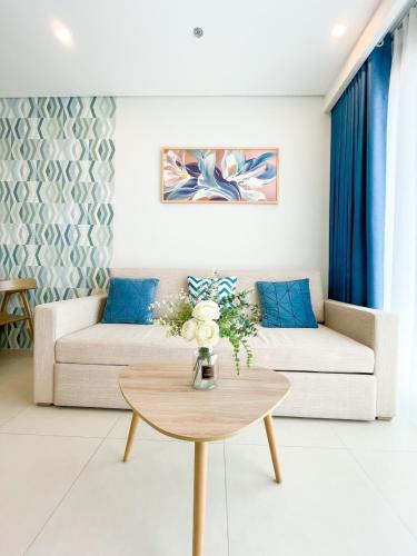 a living room with a couch and a table at THE SONG- CĂN HỘ DU LỊCH 5SAO- FREE hồ bơi- Gần biển - LUXYRY PALM HOME in Vung Tau