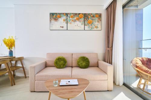 a living room with a couch and a table at THE SONG- CĂN HỘ DU LỊCH 5SAO- FREE hồ bơi- Gần biển - LUXYRY PALM HOME in Vung Tau