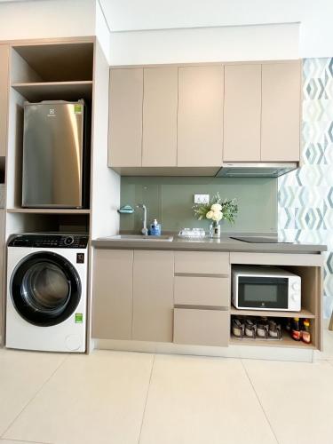 a kitchen with a washing machine and a microwave at THE SONG- CĂN HỘ DU LỊCH 5SAO- FREE hồ bơi- Gần biển - LUXYRY PALM HOME in Vung Tau