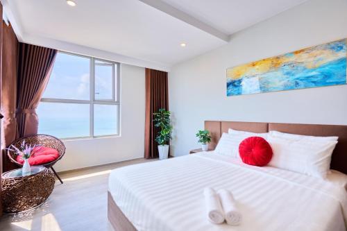 a bedroom with a large bed with red pillows at THE SONG- CĂN HỘ DU LỊCH 5SAO- FREE hồ bơi- Gần biển - LUXYRY PALM HOME in Vung Tau