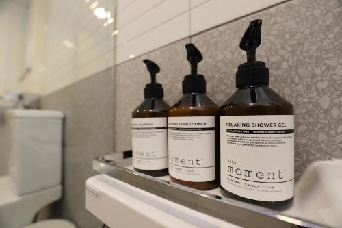 three bottles of shampoo sitting on a counter in a bathroom at Chuncheon Pine Tree Hotel in Chuncheon