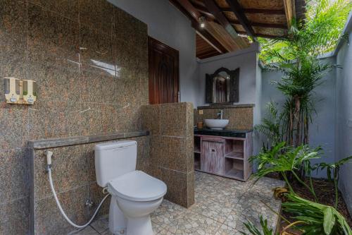 een badkamer met een toilet en een wastafel bij The Tanis Beach Resort Nusa Lembongan in Nusa Lembongan