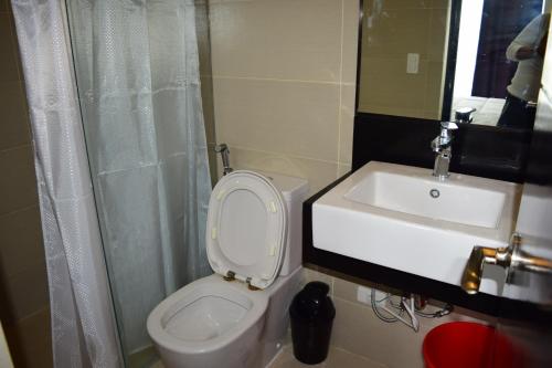 a bathroom with a white toilet and a sink at Consuelo Boracay Unit Rental in Boracay
