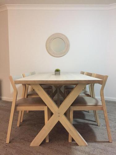 a wooden table with chairs and a mirror on the wall at Club Wyndham Port Macquarie in Port Macquarie
