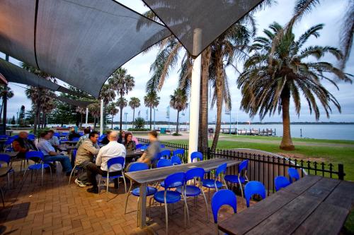 a group of people sitting at tables and chairs at Club Wyndham Port Macquarie in Port Macquarie