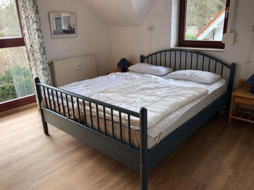 a large bed in a bedroom with a wooden floor at Ferienwohnung-Jim-Knopf-mit-Balkon-zwischen-Strand-Wald-Wiese-im-Suedosten-der-Insel-Ruegen in Gustow