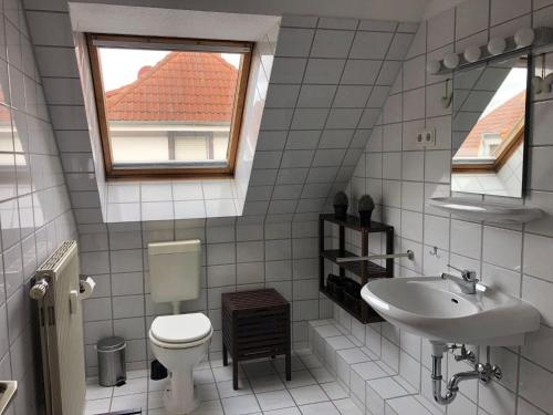 a white bathroom with a toilet and a sink at Ferienwohnung-Jim-Knopf-mit-Balkon-zwischen-Strand-Wald-Wiese-im-Suedosten-der-Insel-Ruegen in Gustow