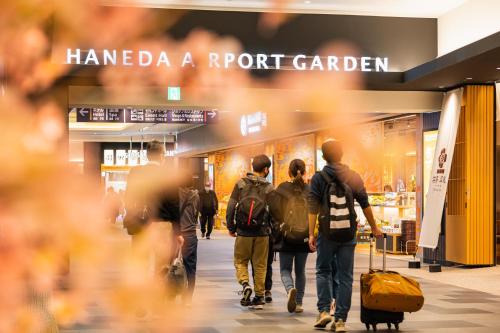a group of people walking in front of a store at Villa Fontaine Grand Haneda Airport in Tokyo