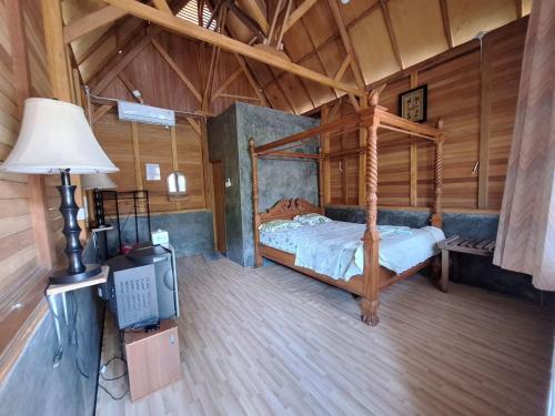 sypialnia z łóżkiem i telewizorem w pokoju w obiekcie Palanta Roemah Kajoe Syariah Villa w mieście Kampungdurian