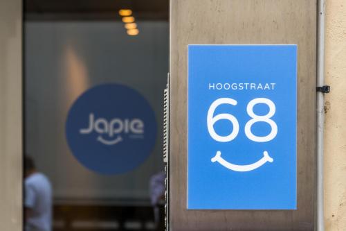 a blue sign on a door with a smile at Japie rooms - in the heart of Antwerp in Antwerp
