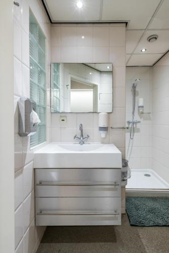 a bathroom with a sink and a mirror and a tub at Japie rooms - in the heart of Antwerp in Antwerp
