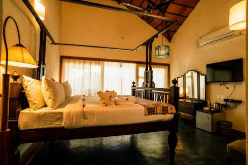 a bedroom with a bed with two teddy bears on it at Cranganor History Café & Riverside Château in Parūr
