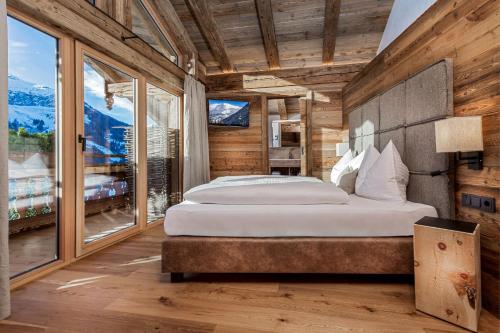 a bedroom with a large bed and a large window at Schönwieshütte in Saalbach-Hinterglemm