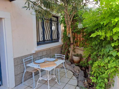 uma mesa e duas cadeiras sentadas num pátio em Le Cottage de Sainte Valière (Jacuzzi et terrasse ) em Sainte-Vallière