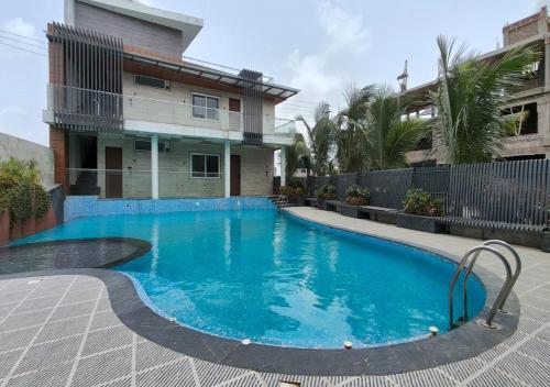 a swimming pool in front of a house at The Sky Imperial Sethji Ni Wadi in Indore