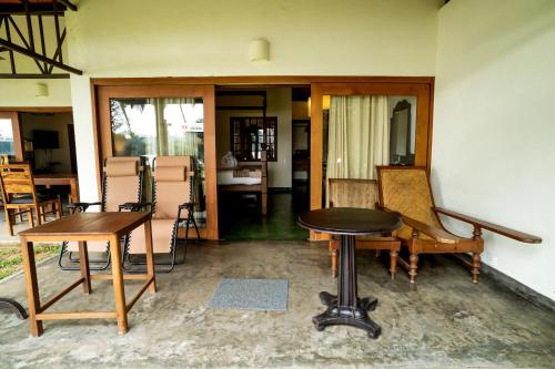a room with a table and some chairs and a table at Cranganor History Café & Riverside Château in Parūr
