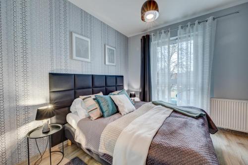 ein Schlafzimmer mit einem großen Bett und einem Fenster in der Unterkunft LM APARTAMENTY NARUTOWICZA Kamienica Nova 2-3 in Stettin