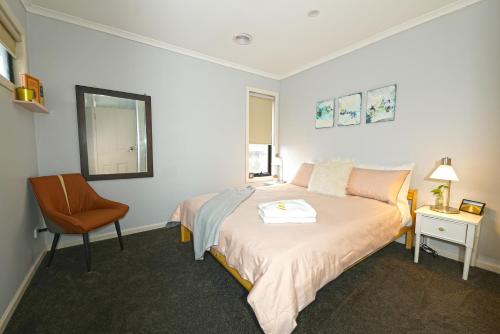 1 dormitorio pequeño con 1 cama y 1 silla en Fawkner Modern 3BR House Netflix WiFi Parking, en Melbourne