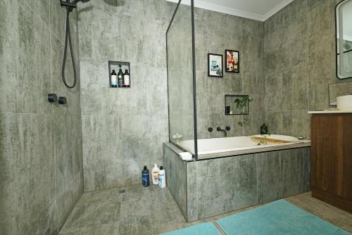 y baño con ducha, bañera y lavamanos. en Fawkner Modern 3BR House Netflix WiFi Parking, en Melbourne