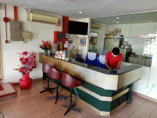 a man sitting at a bar in a restaurant at OYO 90842 Hotel Prai Jaya in Perai