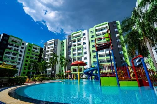 イポーにあるIPOH Waterpark Homestay By SummerStay 5km to IPOH TOWNの一部の建物の前に遊び場付きのスイミングプールがあります。