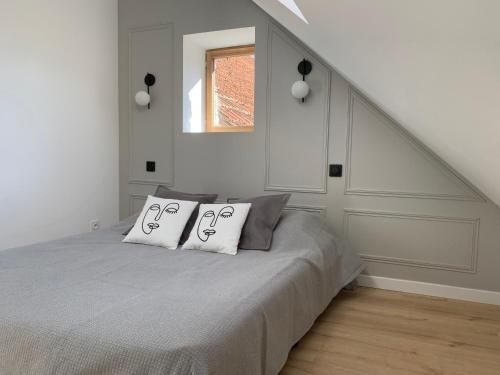 a bedroom with a bed with two pillows on it at Le pinot, 30 min de Reims in Dormans