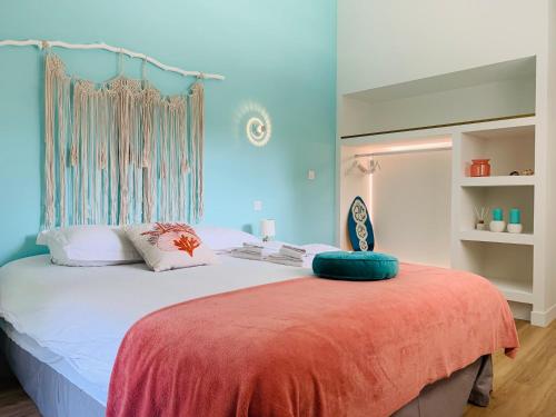 une chambre avec un grand lit aux murs bleus dans l'établissement Le gîte d ici et d ailleurs Ariège Pyrénées, à Baulou