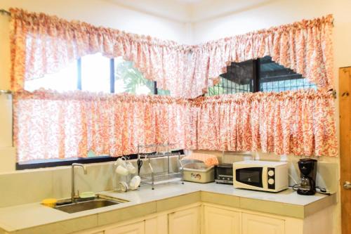 a kitchen with a sink and a window at Balay 8 Suites in Silay