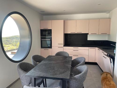 a kitchen with a table and chairs and a window at Les Restanques du lac in La Chapelle