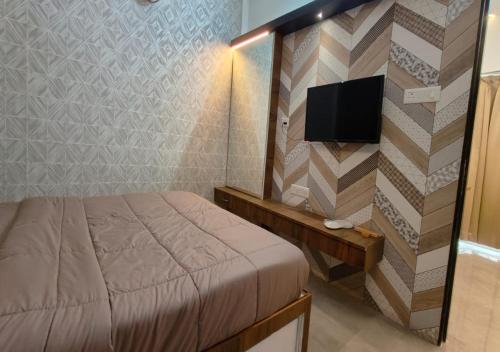 a bedroom with a bed and a flat screen tv at The Sky Imperial Sethji Ni Wadi in Indore
