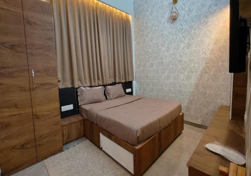 a small bedroom with a bed and a window at The Sky Imperial Sethji Ni Wadi in Indore