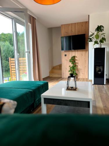 a room with a bed and a table and a tv at Oskarówka Kaszuby z balią in Gołubie