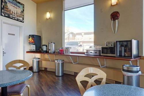 a restaurant with a counter and tables and chairs at Puffin Inn in Anchorage