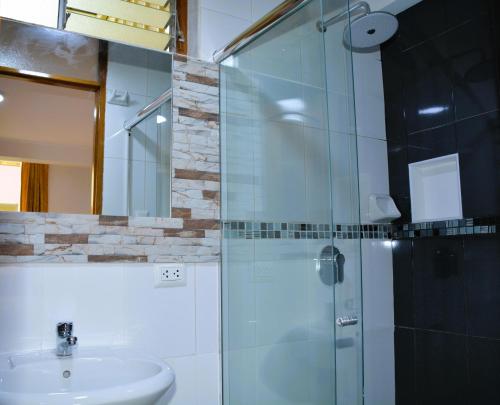 a bathroom with a glass shower and a sink at Hotel Inka Pisac in Pisac