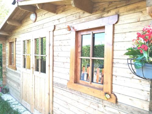 a wooden house with a window on it at Piscine "Mai a Septembre" Jacuzzi Balnéo "La Palmeraie Oasis" toute l'année in Férolles