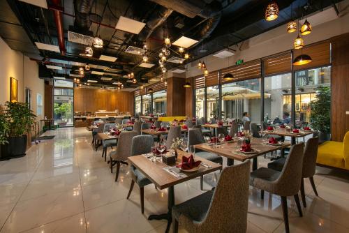 a restaurant with tables and chairs in a building at Nesta - The Grand Hao Nam in Hanoi