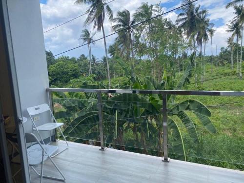 a balcony with a view of a jungle at The Grey House in Bacong
