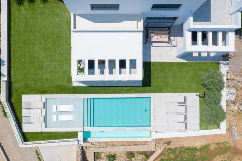 an aerial view of a house with a swimming pool at Villa La Bianca in Koskinou