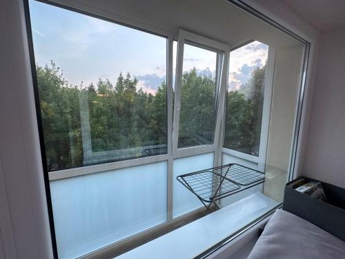 Cette chambre dispose d'une fenêtre offrant une vue sur les arbres. dans l'établissement Cozy Two Room Apartment near city centre, à Alytus