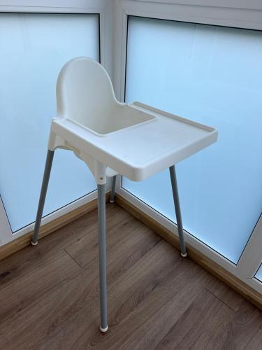 a white chair sitting in front of a window at Cozy Two Room Apartment near city centre in Alytus