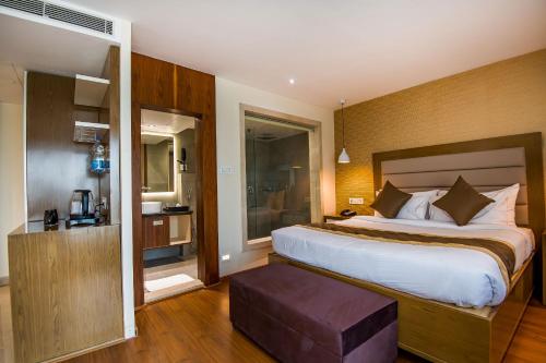 um quarto de hotel com uma cama grande e uma janela em The Imperial Inn em Siliguri