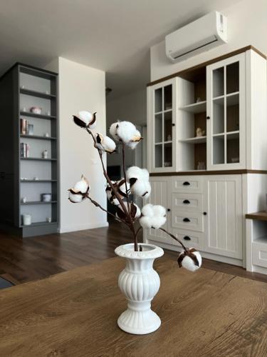 un jarrón blanco con flores blancas en una habitación en Cozy provence apartment in centre of Nitra en Nitra