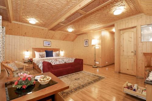 a bedroom with a bed and a living room at Shaw Inn by Stay Pattern in Gulmarg