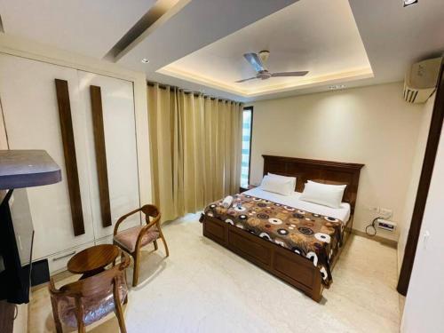 a bedroom with a bed and a table and chairs at Fortune Home Service Apartment 4Bhk D-163 Saket in New Delhi