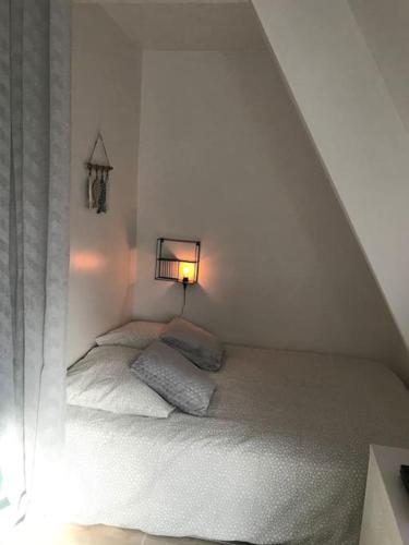 - une chambre blanche avec un lit et une lampe dans l'établissement Cocon douillet 4 personnes à Deauville, 7min à pied de la plage, à Deauville