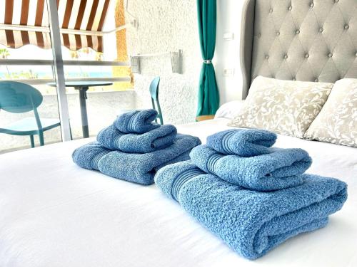 a pile of towels sitting on top of a bed at Borinquen Vista Mar in Playa de las Americas