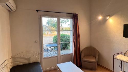 Cette chambre dispose d'une fenêtre, d'une table et d'une chaise. dans l'établissement La villa De Lina 509 -Self Check In -, à Gallargues-le-Montueux